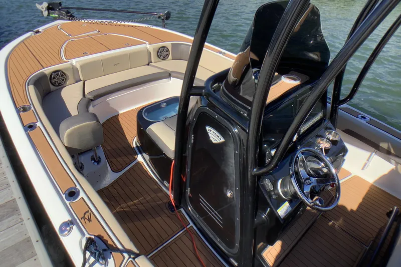 Slide: The Image of 2018 Tidewater 2700 Carolina Bay boat interior with seating and steering console. - 2