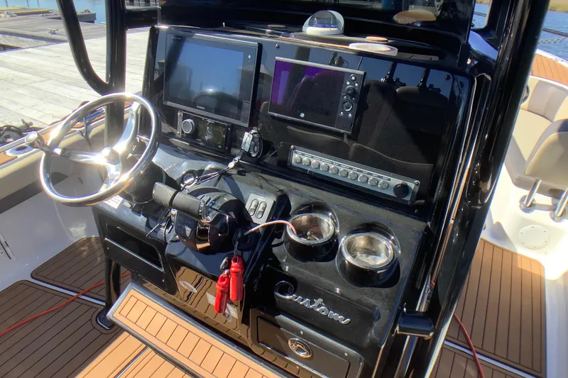 Slide: The Image of 2018 Tidewater 2700 Carolina Bay boat dashboard with steering wheel and navigation controls. - 3