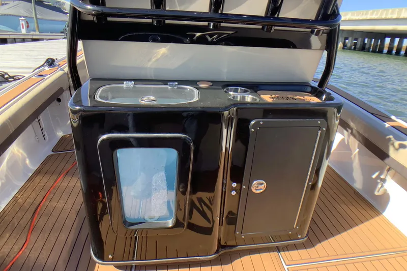Slide: The Image of 2018 Tidewater 2700 Carolina Bay boat interior with sleek black console and wooden deck. - 4