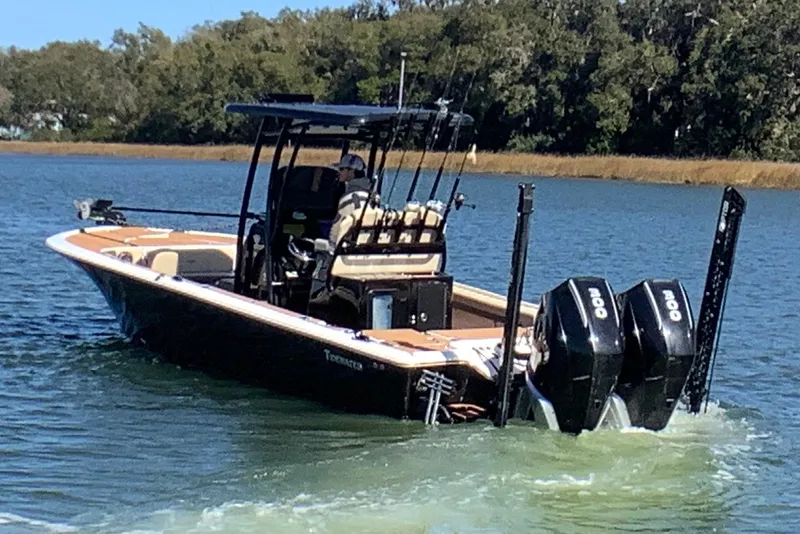 Slide: The Image of 2018 Tidewater 2700 Carolina Bay boat on water, equipped with dual engines. - 6