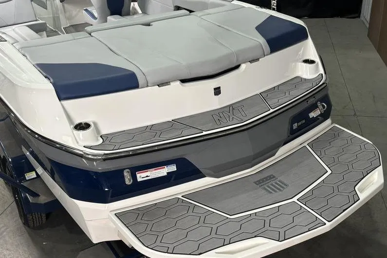 Slide: The Image of 2023 MasterCraft NXT24 boat rear view with cushioned seating and non-slip deck. - 11
