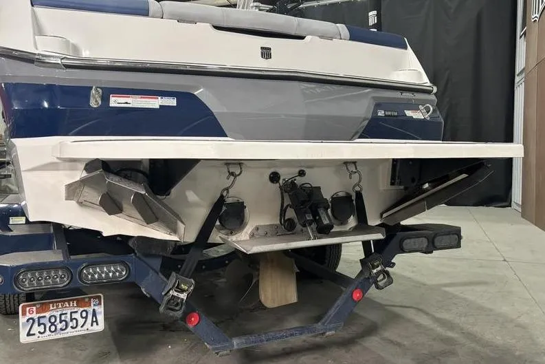 Slide: The Image of 2023 MasterCraft NXT24 boat rear view with Utah license plate in a garage setting. - 13