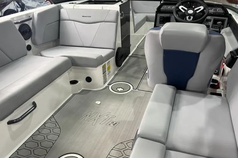 Slide: The Image of 2023 MasterCraft NXT24 boat interior with gray seating and modern dashboard. - 5