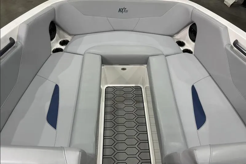 Slide: The Image of 2023 MasterCraft NXT24 boat interior with gray seating and hexagonal floor design. - 7