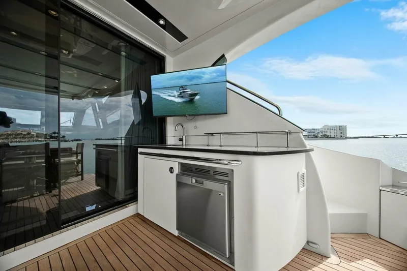 Slide: The Image of 2014 Marquis 630 Sport Yacht deck with TV, kitchenette, and ocean view. - 20
