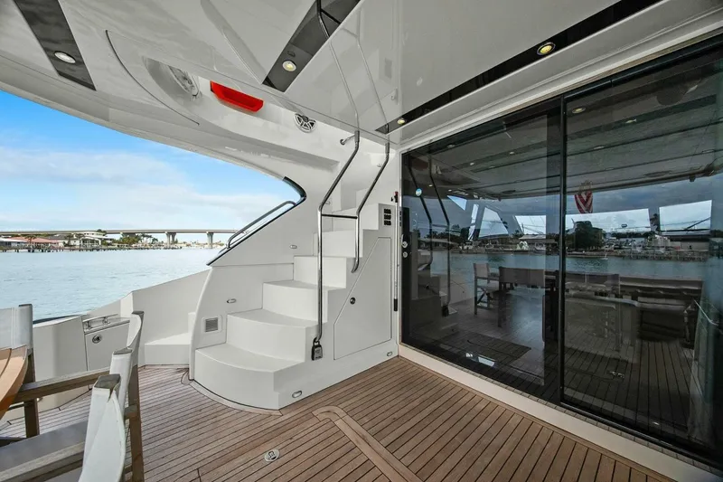 Slide: The Image of Luxurious 2014 Marquis 630 Sport Yacht deck with elegant seating and scenic water view. - 23