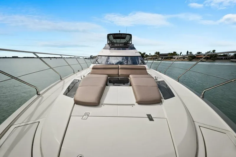 Slide: The Image of 2014 Marquis 630 Sport Yacht on calm water, featuring spacious deck and luxurious seating. - 26