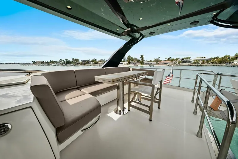 Slide: The Image of Luxurious 2014 Marquis 630 Sport Yacht deck with seating and table, overlooking serene waters. - 35