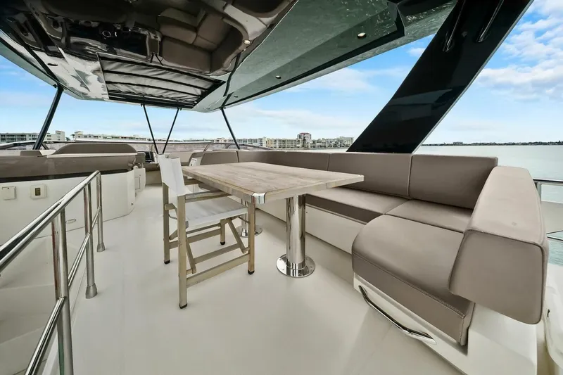 Slide: The Image of Luxurious 2014 Marquis 630 Sport Yacht deck with seating and table, overlooking serene waters. - 37