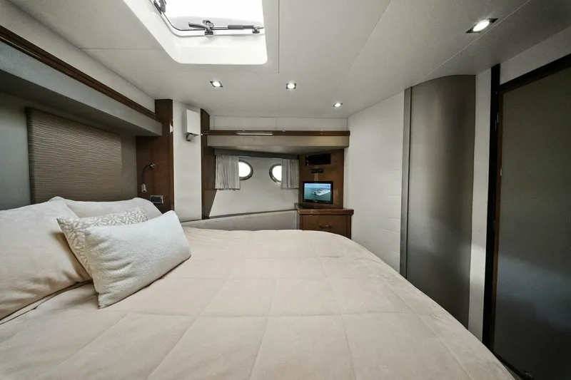 Slide: The Image of Luxurious bedroom interior of 2014 Marquis 630 Sport Yacht with cozy bedding and porthole windows. - 42