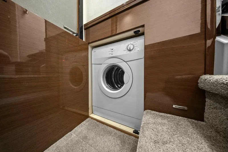 Slide: The Image of Built-in washing machine on 2014 Marquis 630 Sport Yacht, integrated into wooden cabinetry. - 52