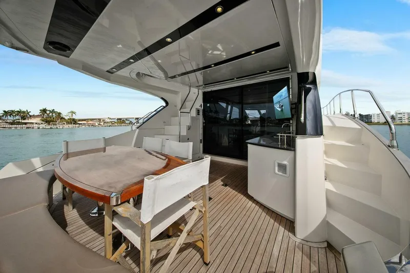 Slide: The Image of Luxurious 2014 Marquis 630 Sport Yacht deck with dining area and ocean view. - 6