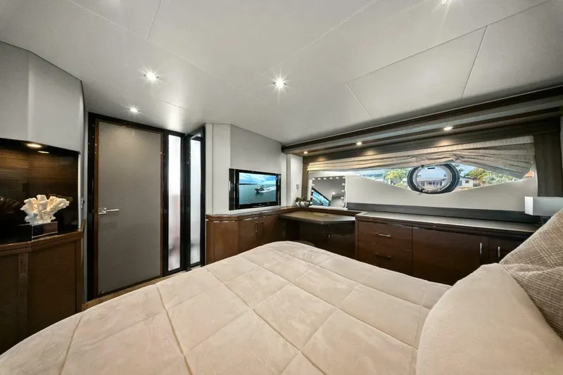Slide: The Image of Luxurious interior of 2014 Marquis 630 Sport Yacht bedroom with modern decor and porthole view. - 60
