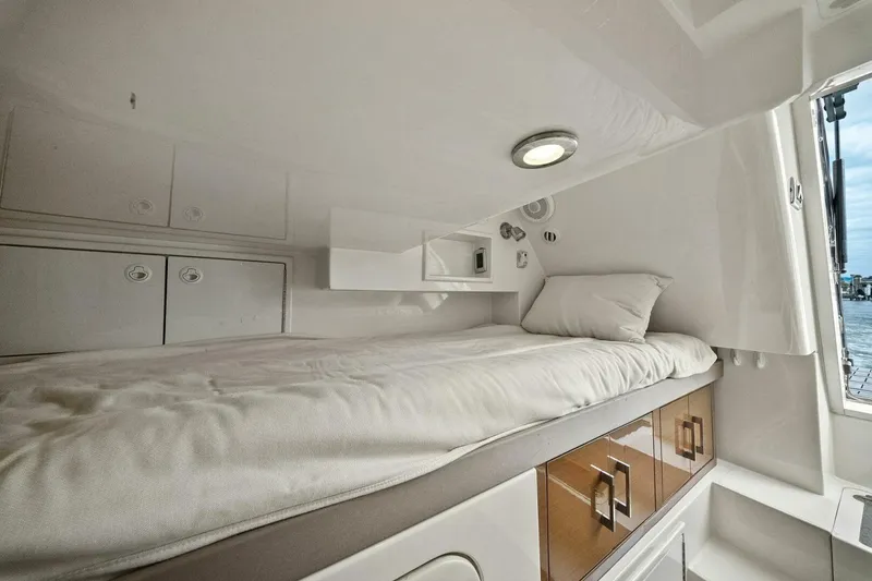 Slide: The Image of Cozy cabin interior of 2014 Marquis 630 Sport Yacht with bed and storage. - 63