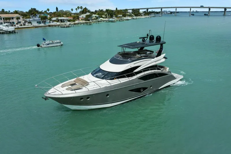 Slide: The Image of 2014 Marquis 630 Sport Yacht cruising in turquoise waters near coastal homes. - 71