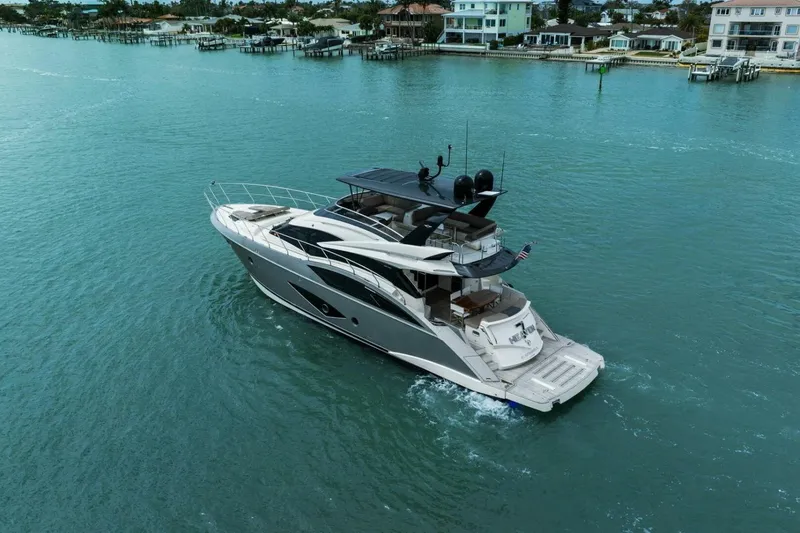 Slide: The Image of 2014 Marquis 630 Sport Yacht cruising in a scenic coastal area. - 72