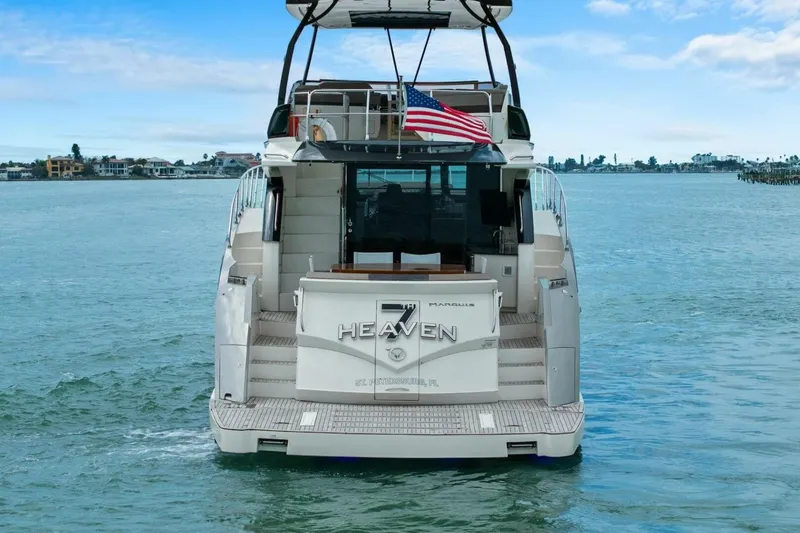 Slide: The Image of 2014 Marquis 630 Sport Yacht on water, rear view with American flag. - 73