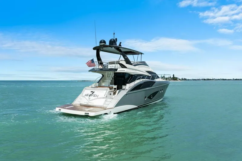 Slide: The Image of 2014 Marquis 630 Sport Yacht cruising on open water under a clear blue sky. - 74