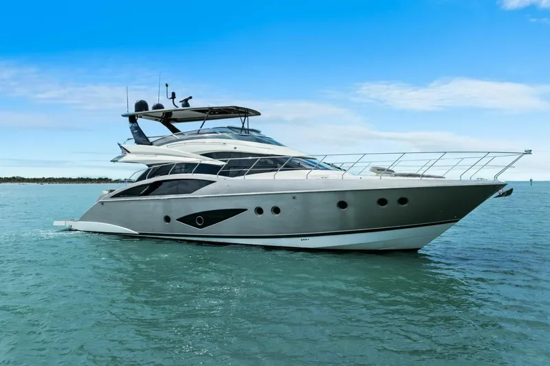 Slide: The Image of 2014 Marquis 630 Sport Yacht cruising on calm blue waters under a clear sky. - 75