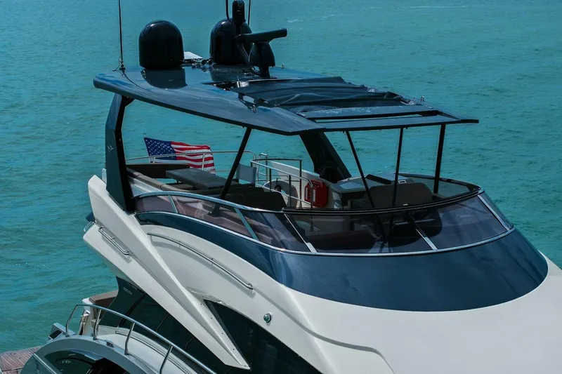 Slide: The Image of 2014 Marquis 630 Sport Yacht on blue ocean with American flag. - 77