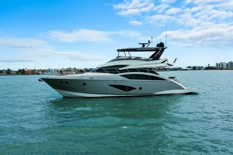 Slide: The Image of 2014 Marquis 630 Sport Yacht on calm waters under a blue sky. - 78