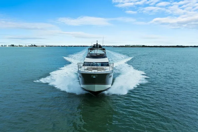 Slide: The Image of 2014 Marquis 630 Sport Yacht cruising on open water under a clear blue sky. - 82