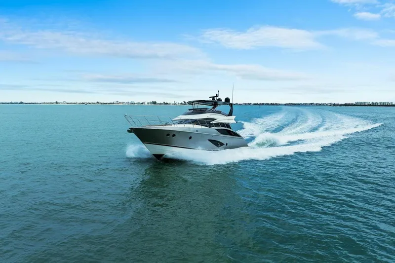 Slide: The Image of 2014 Marquis 630 Sport Yacht cruising on open water under a clear blue sky. - 83