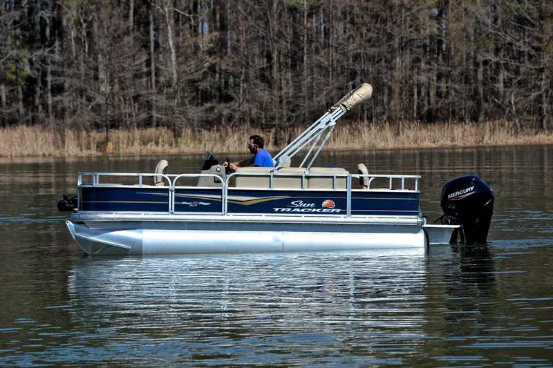 Slide: The Image of 2024 Sun Tracker Bass Buggy 18 DLX pontoon boat on a calm lake. - 10