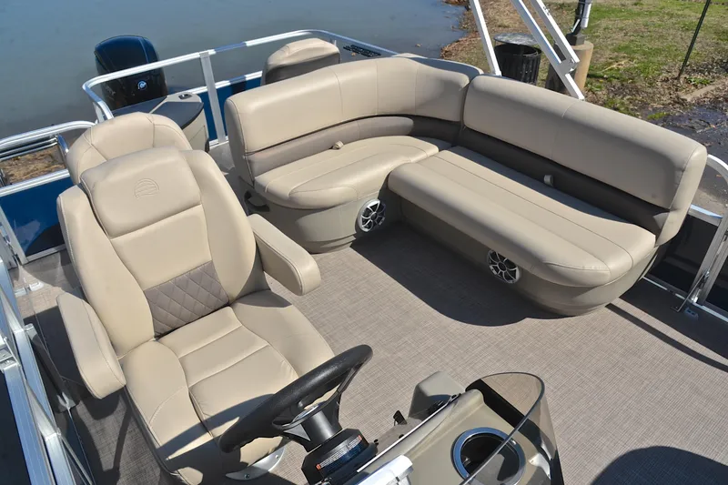 Slide: The Image of 2024 Sun Tracker Bass Buggy 18 DLX pontoon boat interior with beige seating and steering console. - 23