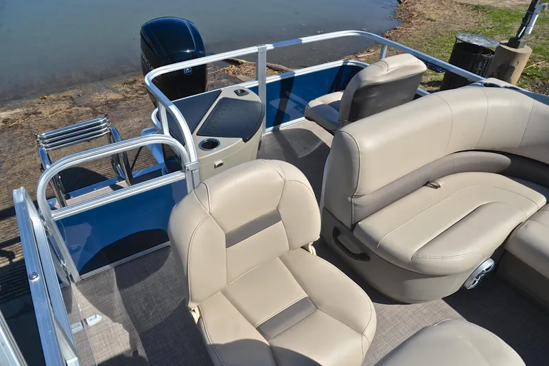 Slide: The Image of 2024 Sun Tracker Bass Buggy 18 DLX pontoon boat with beige seating and blue exterior. - 24