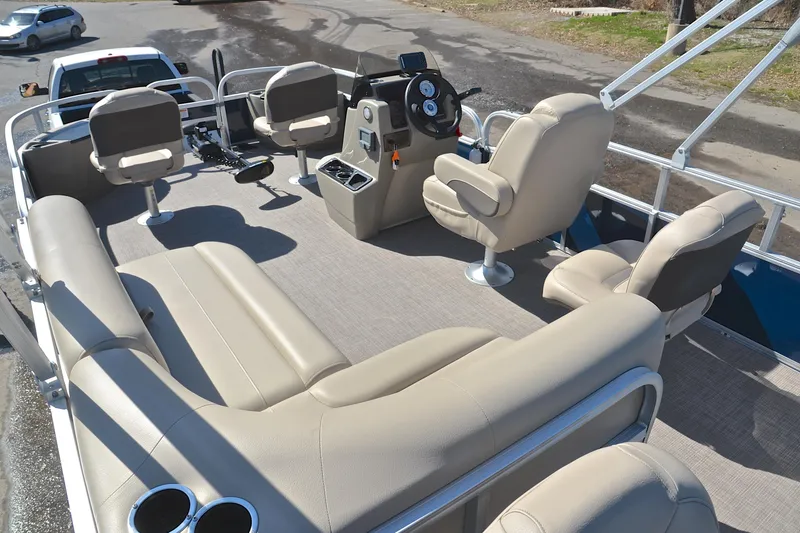 Slide: The Image of 2024 Sun Tracker Bass Buggy 18 DLX pontoon boat interior with beige seating and steering console. - 25