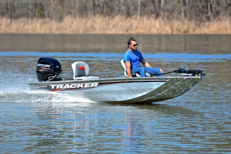 The Image of Man driving 2017 Bass Tracker Pro 16 boat on a calm lake. - 1
