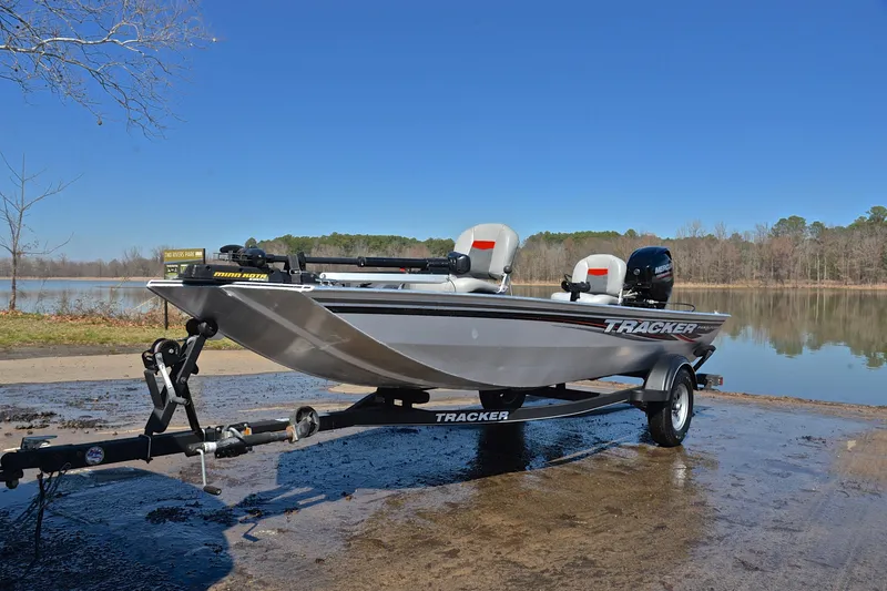 Slide: The Image of 2017 Bass Tracker Pro 16 boat on trailer by a lake under clear blue sky. - 10