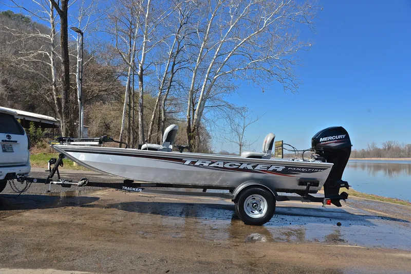 Slide: The Image of 2017 Bass Tracker Pro 16 boat on trailer by a lake, clear blue sky. - 11