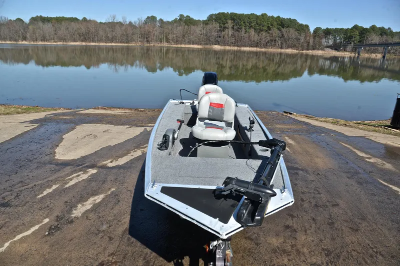 Slide: The Image of 2017 Bass Tracker Pro 16 boat on a ramp by a serene lake. - 17