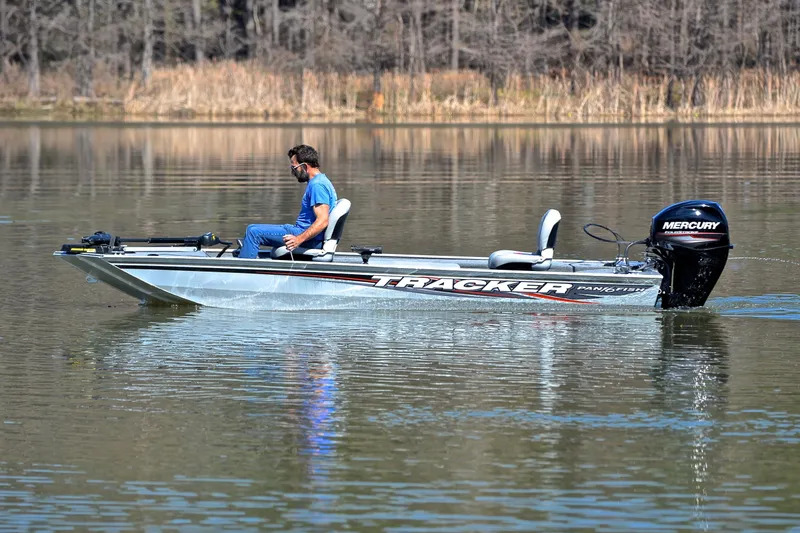 Slide: The Image of 2017 Bass Tracker Pro 16 boat on a calm lake with a Mercury engine. - 9