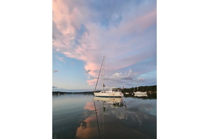 The Image of Sailboat Catalina Morgan 440, 2005, on calm water under pink sunset sky. - 0