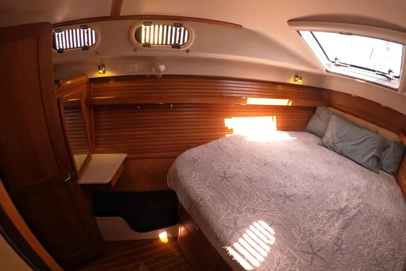 Slide: The Image of Cozy cabin interior of 2005 Catalina Morgan 440 sailboat with wooden paneling and comfortable bedding. - 28