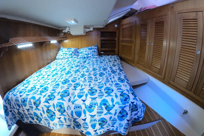 Slide: The Image of Cozy cabin interior of 2005 Catalina Morgan 440 with nautical-themed bedding and wooden cabinetry. - 33