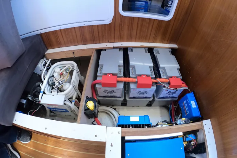 Slide: The Image of Engine compartment of a 2005 Catalina Morgan 440 sailboat, featuring batteries and electrical components. - 37