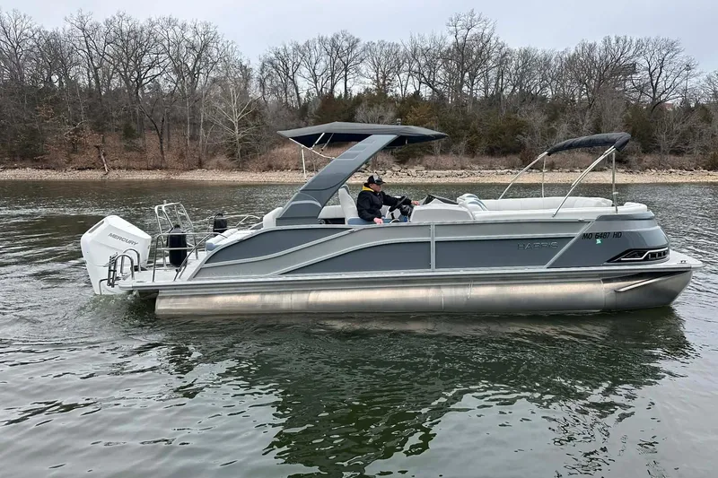 The Image of 2024 Harris Grand Mariner 250 pontoon boat cruising on a calm lake. - 0