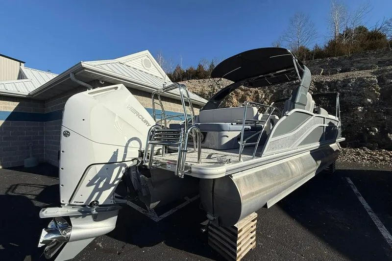 Slide: The Image of 2024 Harris Grand Mariner 250 pontoon boat with Mercury engine, parked outdoors. - 1