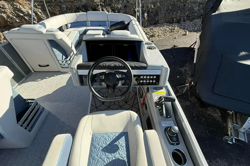 Slide: The Image of 2024 Harris Grand Mariner 250 boat interior with steering wheel and seating area. - 4
