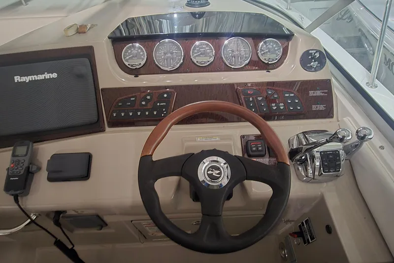 Slide: The Image of 2009 Sea Ray Sundancer 350 helm with Raymarine navigation and wood-accented controls. - 10
