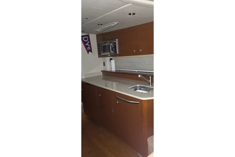 Slide: The Image of 2009 Sea Ray Sundancer 350 yacht kitchen with wood cabinets and modern appliances. - 16