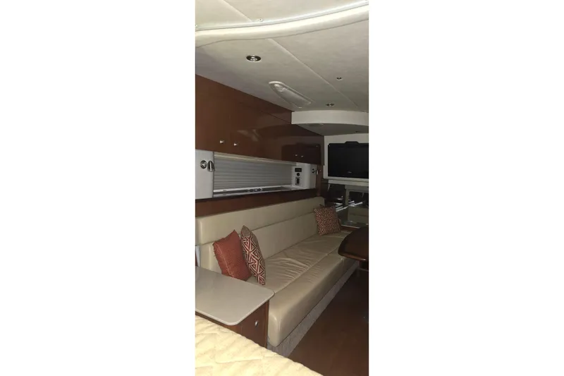 Slide: The Image of Interior of 2009 Sea Ray Sundancer 350, featuring a cozy seating area with cushions. - 19
