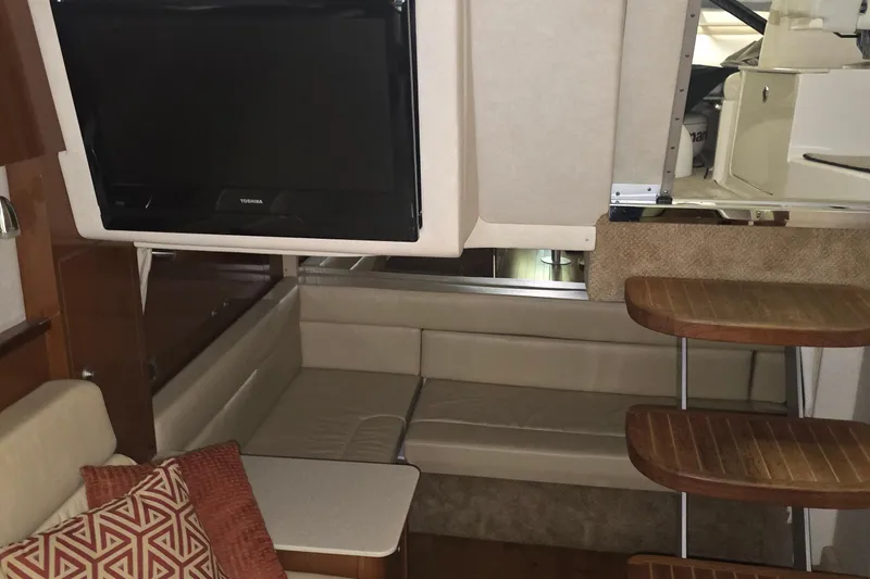 Slide: The Image of Interior of 2009 Sea Ray Sundancer 350 with TV, seating, and wooden steps. - 23