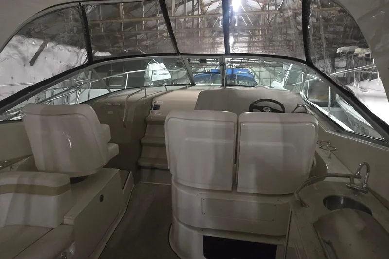 Slide: The Image of 2009 Sea Ray Sundancer 350 interior with helm, seating, and sink in a covered storage area. - 8