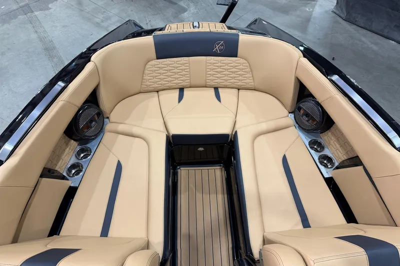 Slide: The Image of 2023 MasterCraft X24 boat interior with tan leather seating and cup holders. - 10