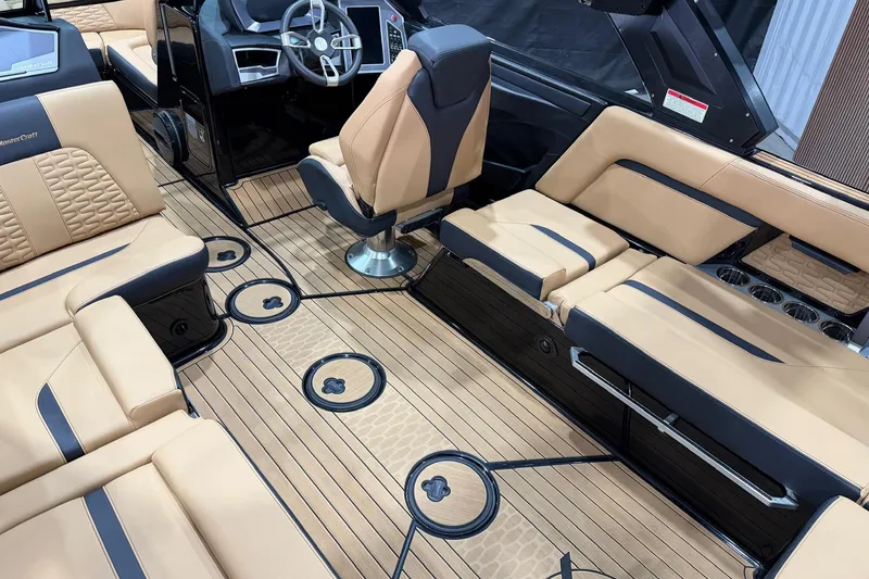 Slide: The Image of 2023 MasterCraft X24 boat interior with tan and black seating, modern dashboard, and sleek design. - 9